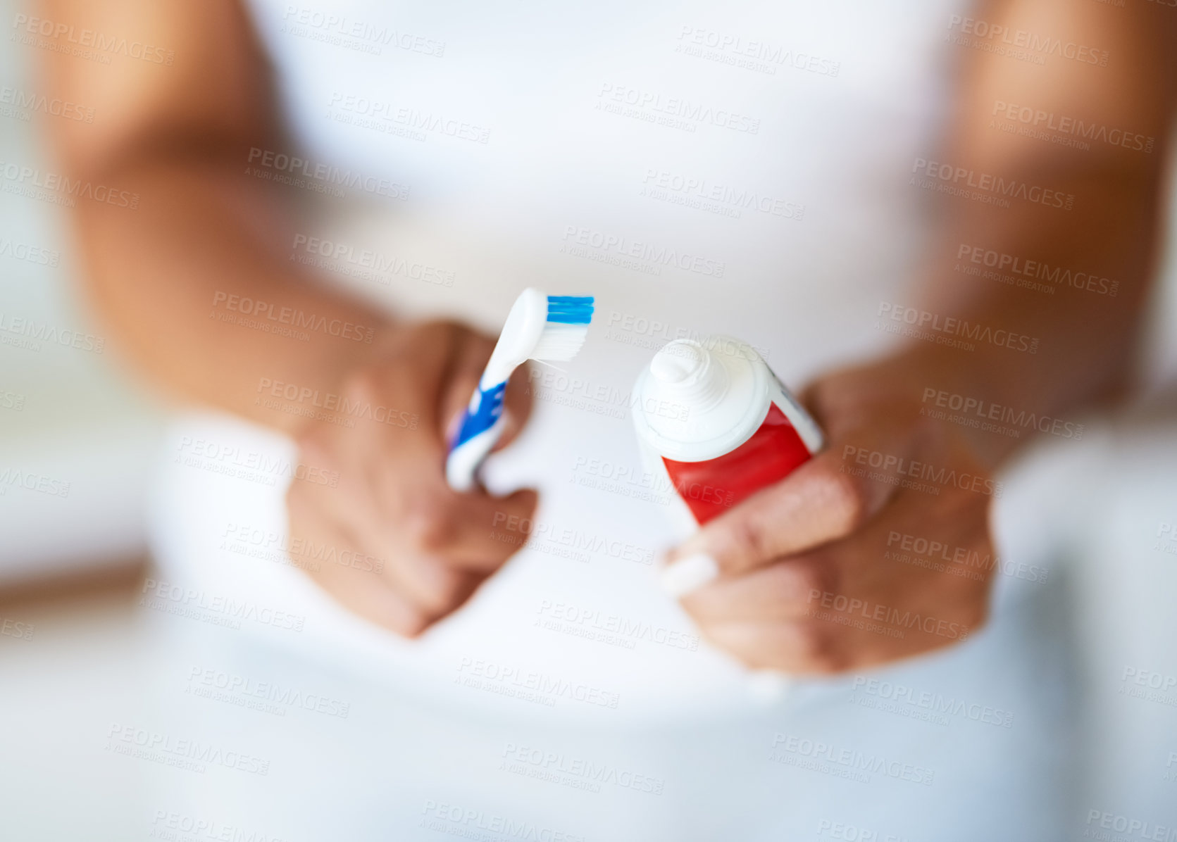 Buy stock photo Cropped shot of a woman putting toothpaste on a toothbrush