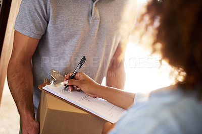 Buy stock photo Closeup shot of a woman signing for her delivery from the courier