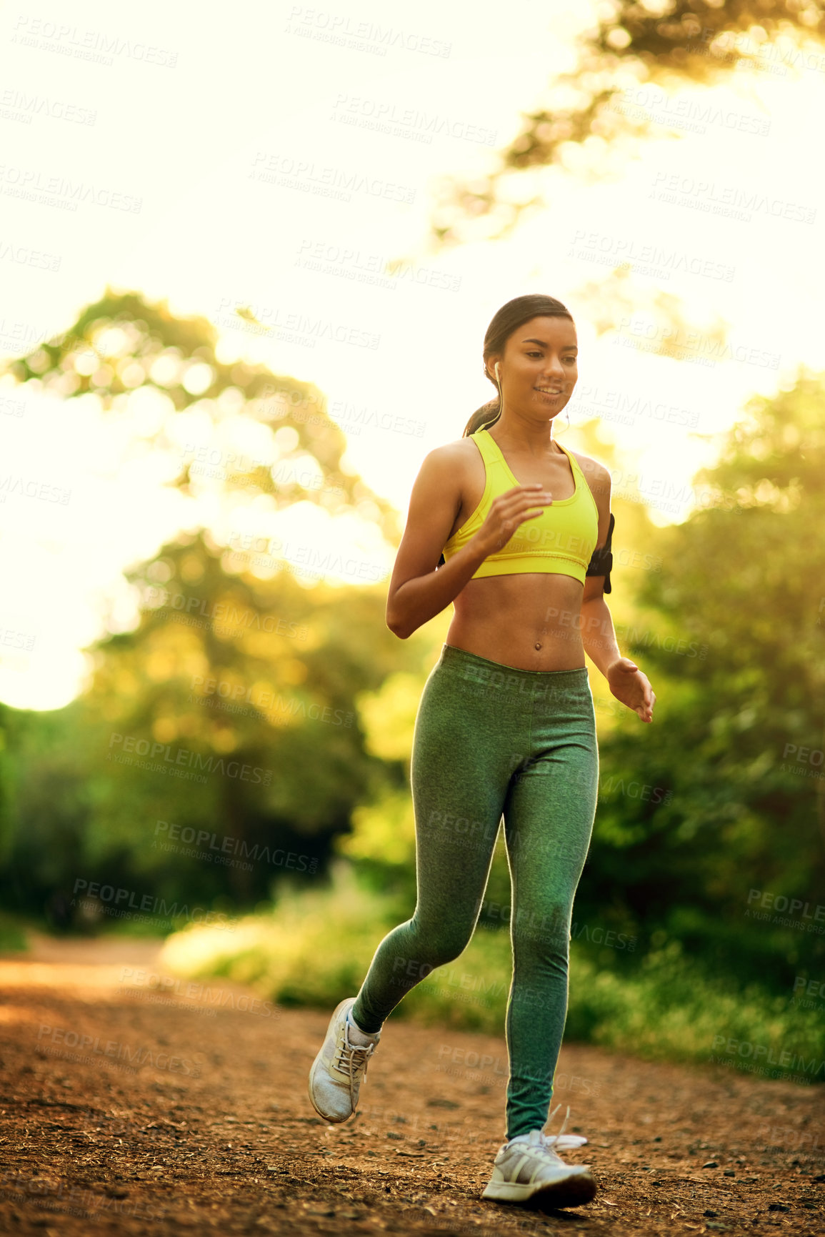 Buy stock photo Shot of a young woman running in a natural environment