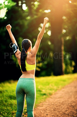 Buy stock photo Rearview shot of a sporty young woman celebrating a victory