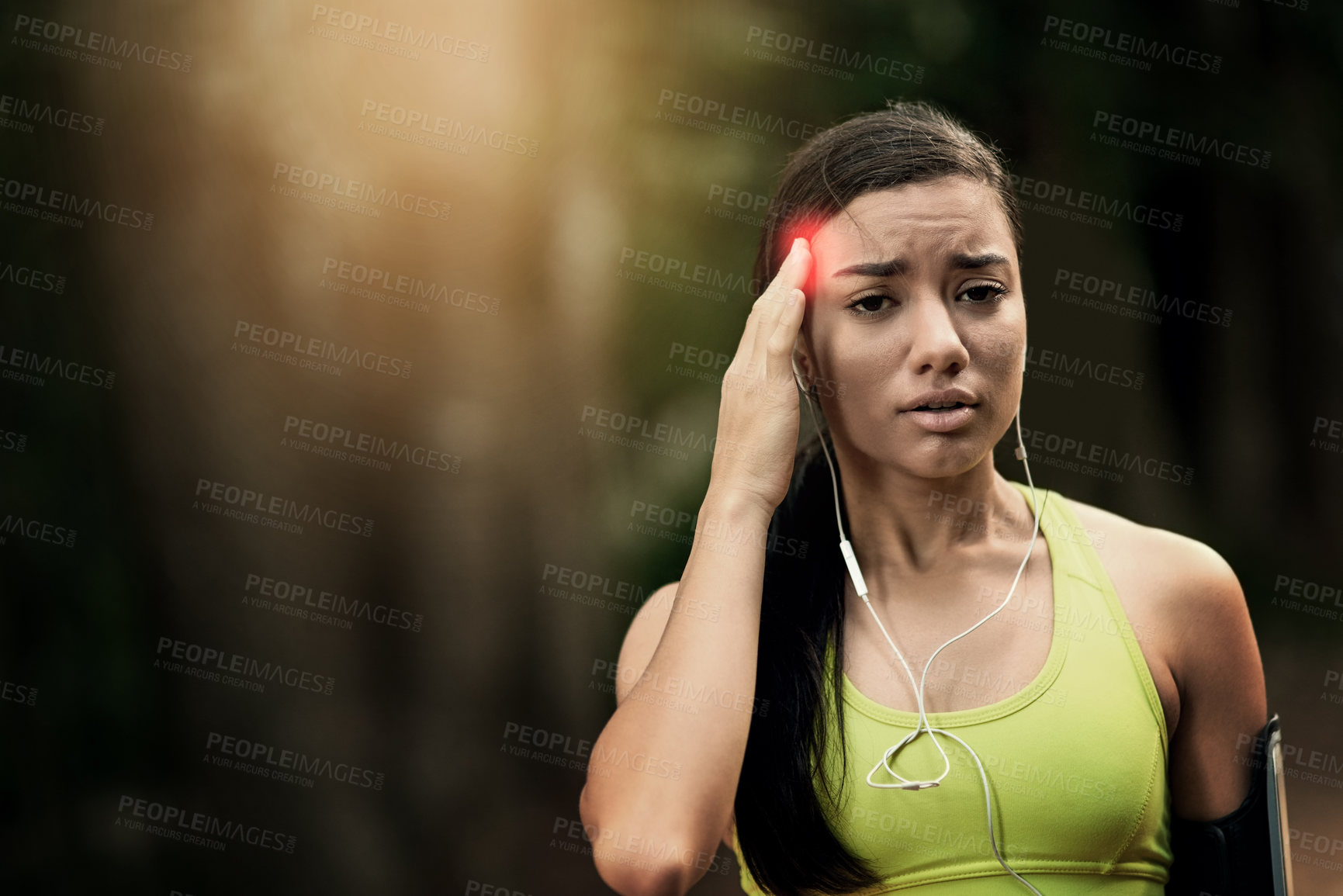 Buy stock photo Shot of a sporty young woman suffering from a headache