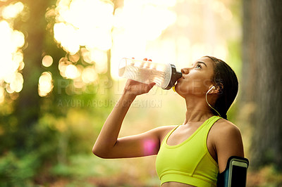 Buy stock photo Cropped shot of a young woman drinking water after her workout
