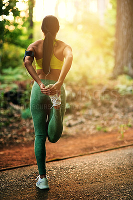 Buy stock photo Shot of a young woman stretching before her run