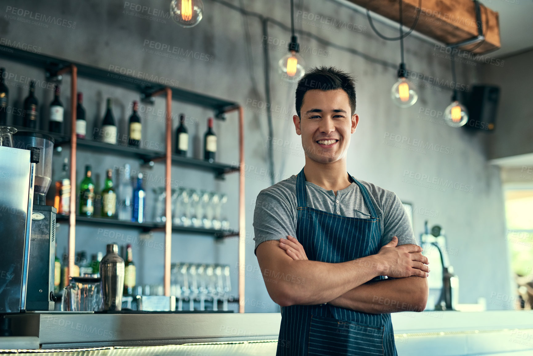 Buy stock photo Cropped portrait of a young man standing with his arms folded in his coffee shop
