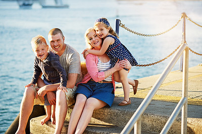 Buy stock photo Portrait of a family with young children posing together by the harbor