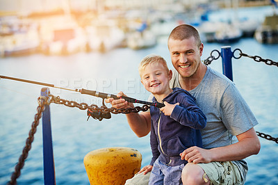 Buy stock photo Portrait of a father and his little boy fishing together at the harbor