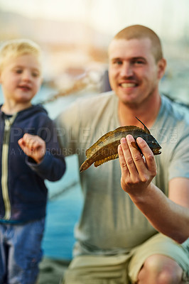 Buy stock photo Portrait of a father and his little boy fishing together at the harbor