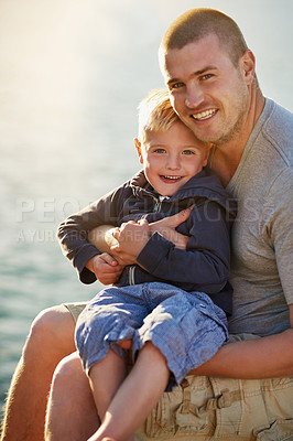 Buy stock photo Portrait of a father bonding with his little boy while they sit by the harbor