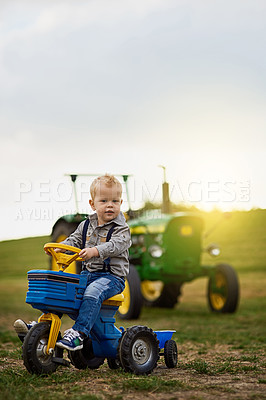 Buy stock photo Portrait of an adorable little boy riding a toy truck on a farm