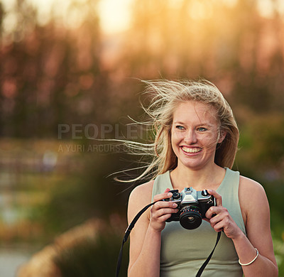 Buy stock photo Cropped shot of a young woman taking photos on her camera outside