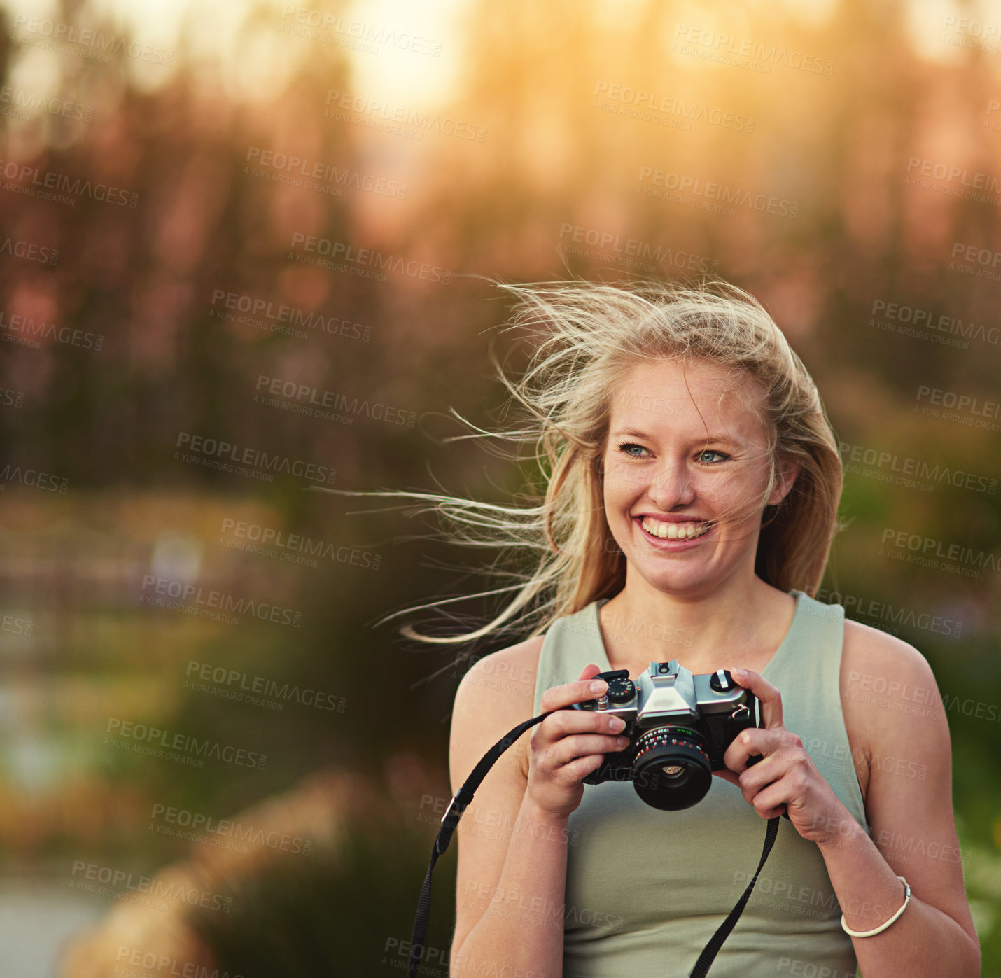 Buy stock photo Cropped shot of a young woman taking photos on her camera outside
