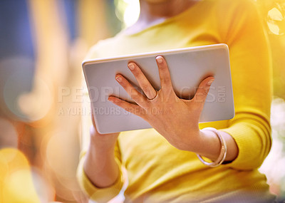 Buy stock photo Cropped shot of an unrecognizable young woman using her tablet outside