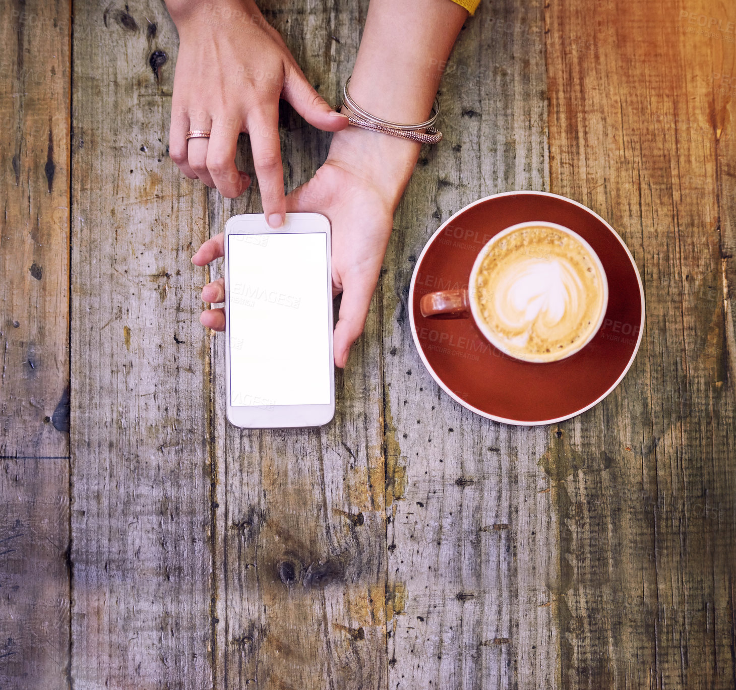 Buy stock photo High angle shot of a woman using her cellphone and having a cup of coffee
