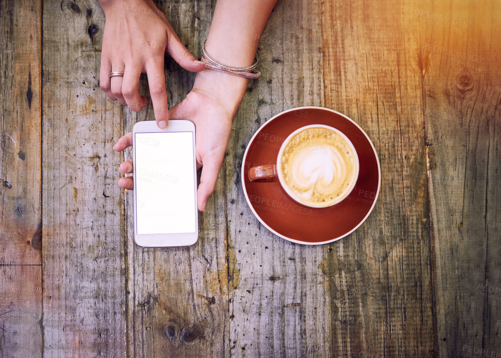 Buy stock photo High angle shot of a woman using her cellphone and having a cup of coffee