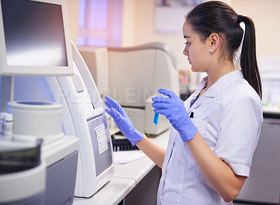 Buy stock photo Shot of a young scientist conducting a medical test in a laboratory