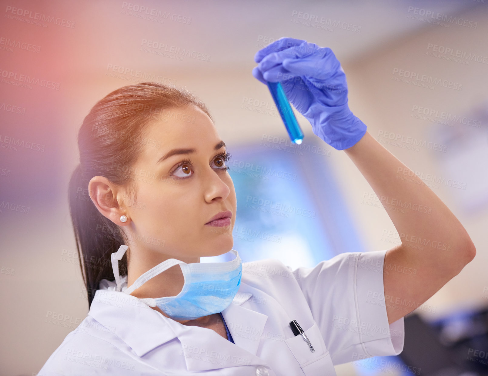 Buy stock photo Shot of a young scientist examining liquid in a test tube in a laboratory