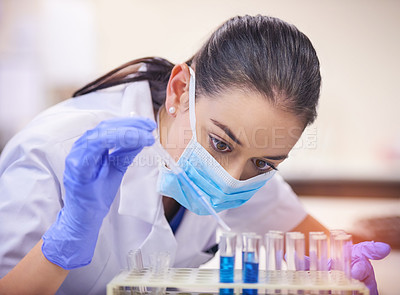 Buy stock photo Shot of a young scientist transferring liquid from a pipette to a test tube in a laboratory