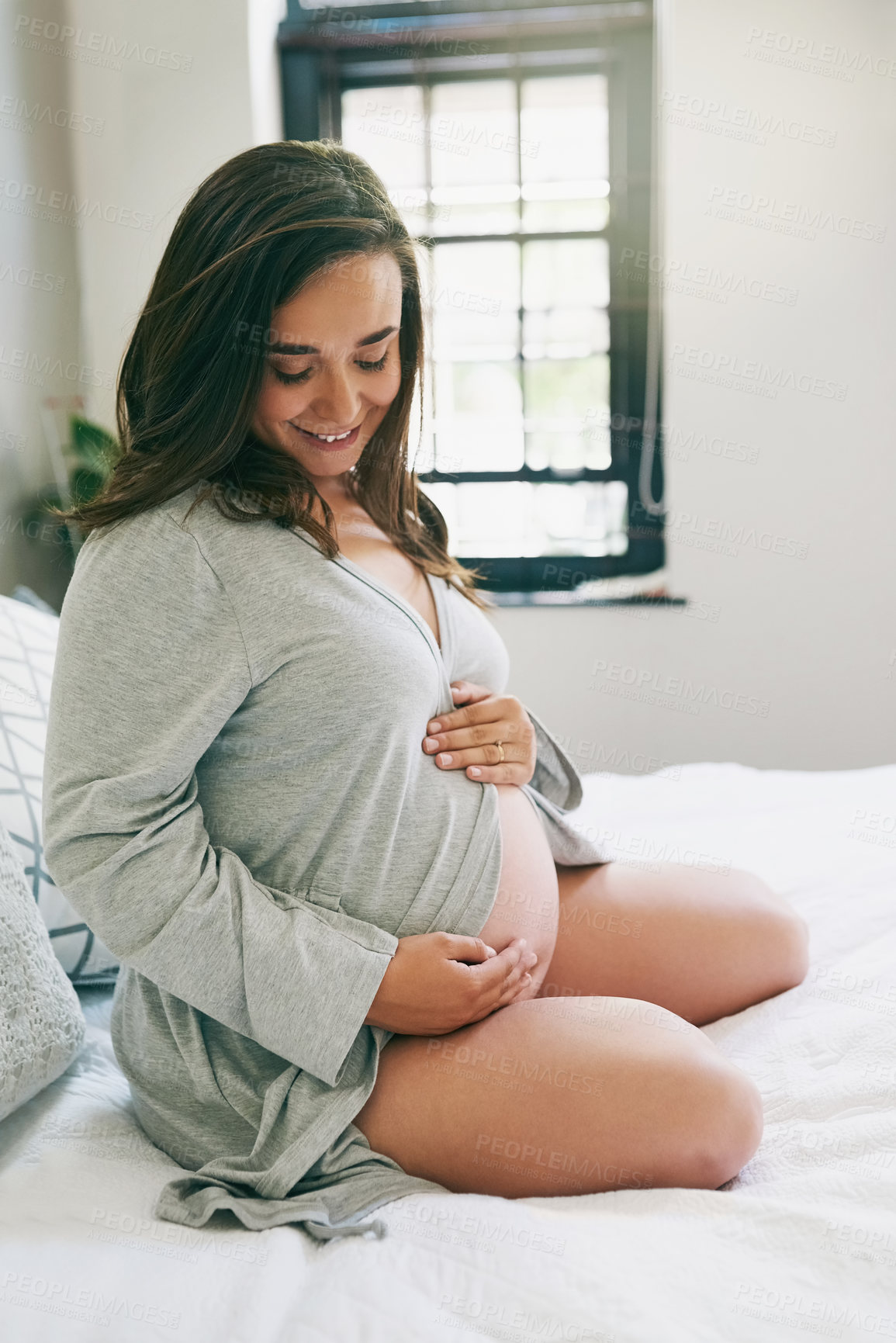 Buy stock photo Shot of a young pregnant woman relaxing at home