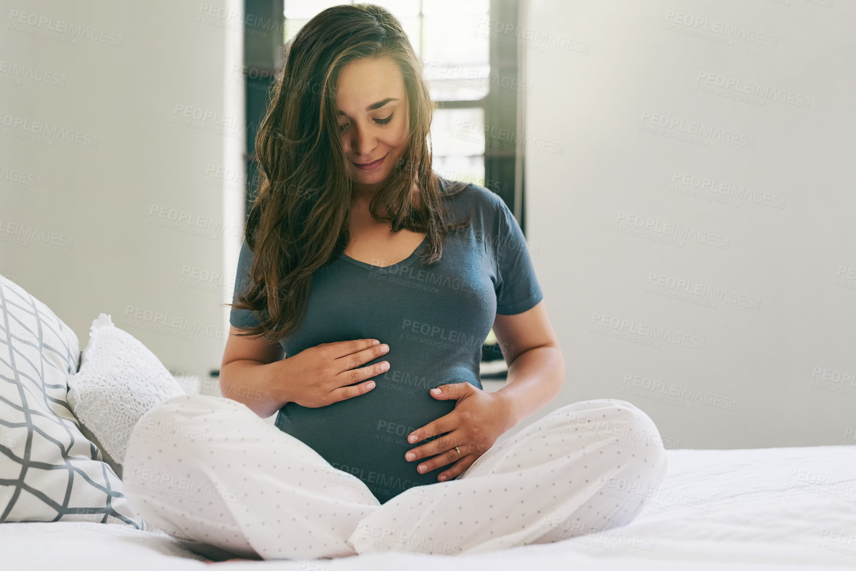 Buy stock photo Shot of a young pregnant woman relaxing at home