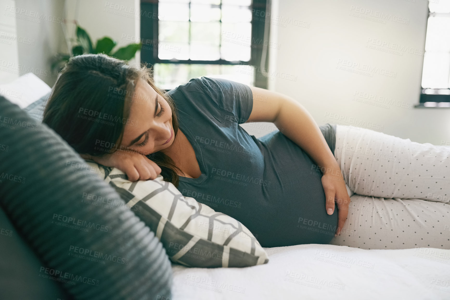 Buy stock photo Shot of a young pregnant woman relaxing at home