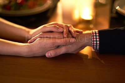 Buy stock photo Cropped shot of a young couple holding hands