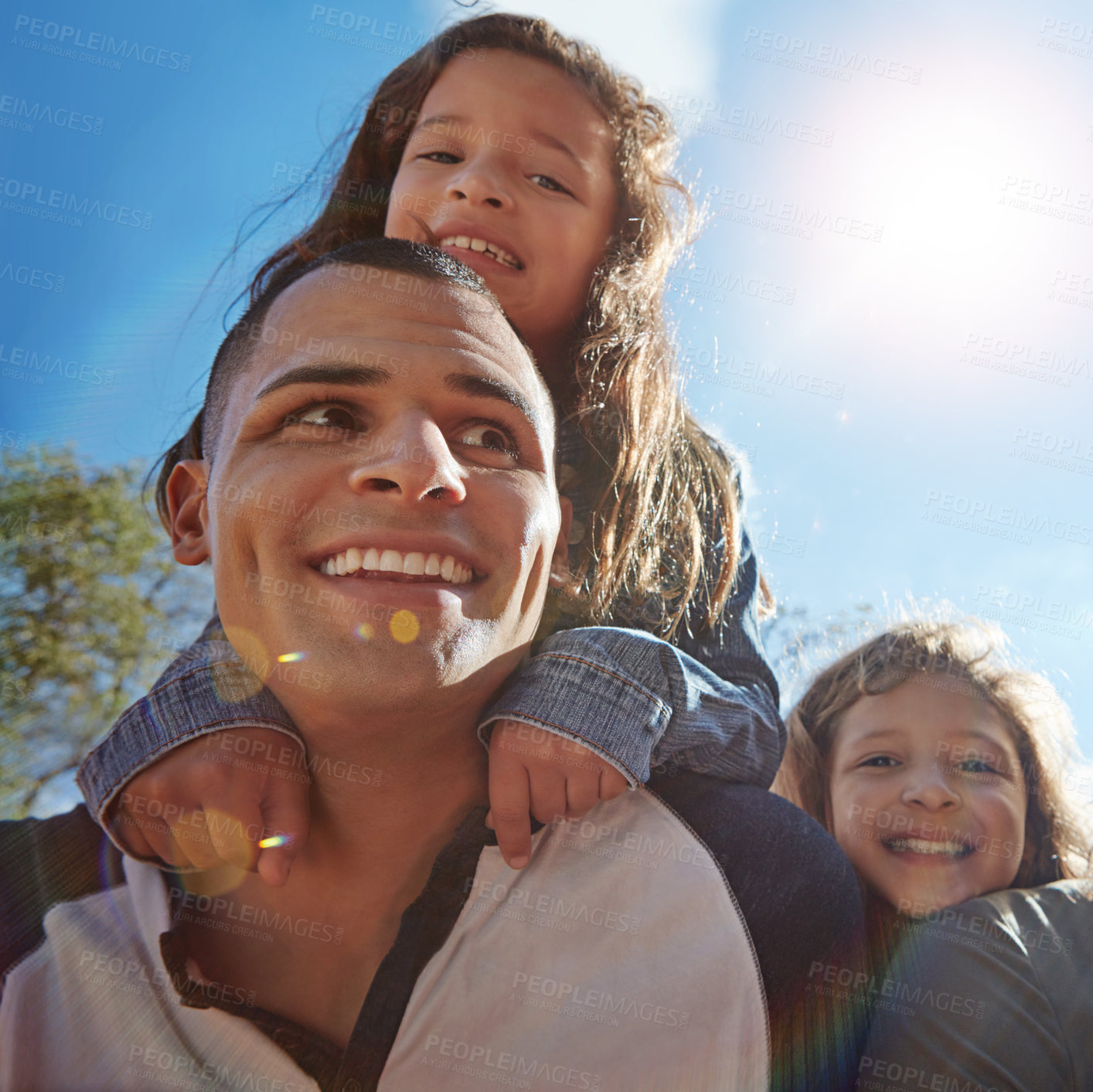 Buy stock photo Portrait of a happy young man spending time with his daughters outdoors