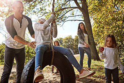 Buy stock photo Shot of a happy father pushing his daughter on a tyre swing