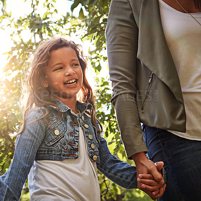 Buy stock photo Shot of a happy little girl going for a walk with her mother through a garden