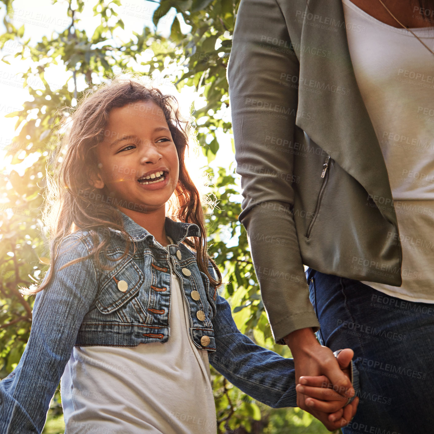 Buy stock photo Shot of a happy little girl going for a walk with her mother through a garden