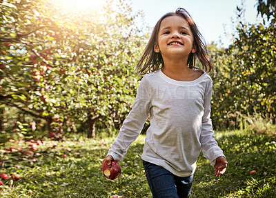 Buy stock photo Shot of an adorable little girl having fun in an apple orchard