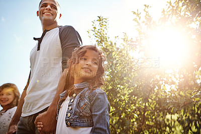 Buy stock photo Shot of a happy young man spending time with his daughters outdoors