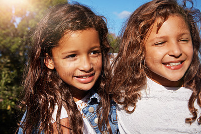 Buy stock photo Shot of two happy young sisters bonding outdoors