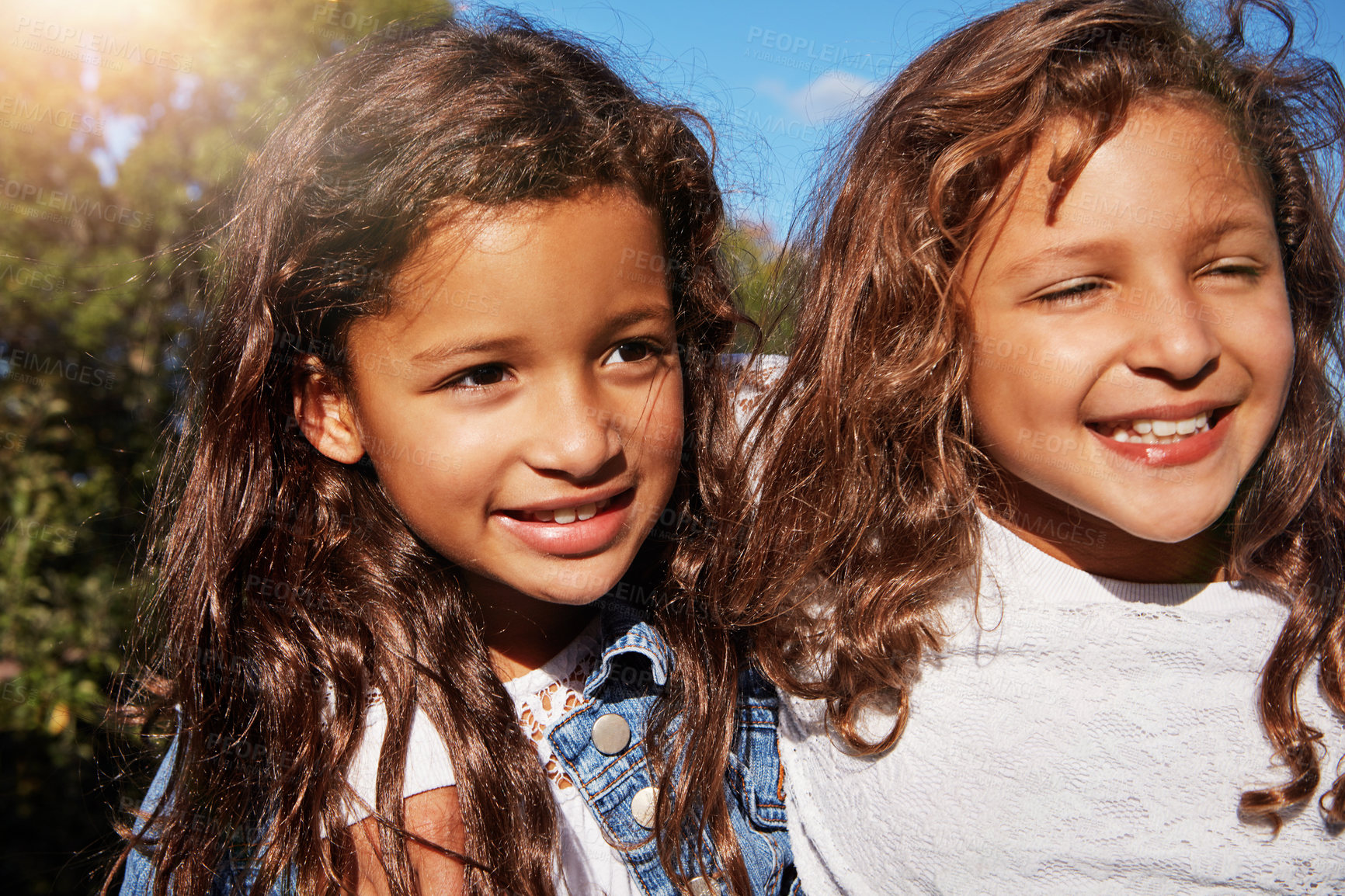 Buy stock photo Shot of two happy young sisters bonding outdoors