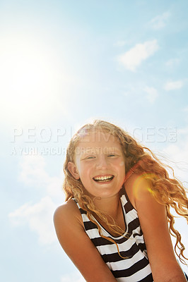 Buy stock photo Portrait of a happy girl standing outside on a bright summer’s day