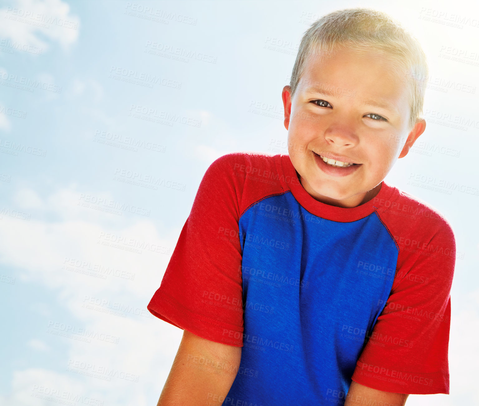 Buy stock photo Portrait of a happy boy standing outside on a bright summer’s day