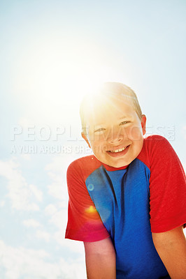 Buy stock photo Portrait of a happy boy standing outside on a bright summer’s day