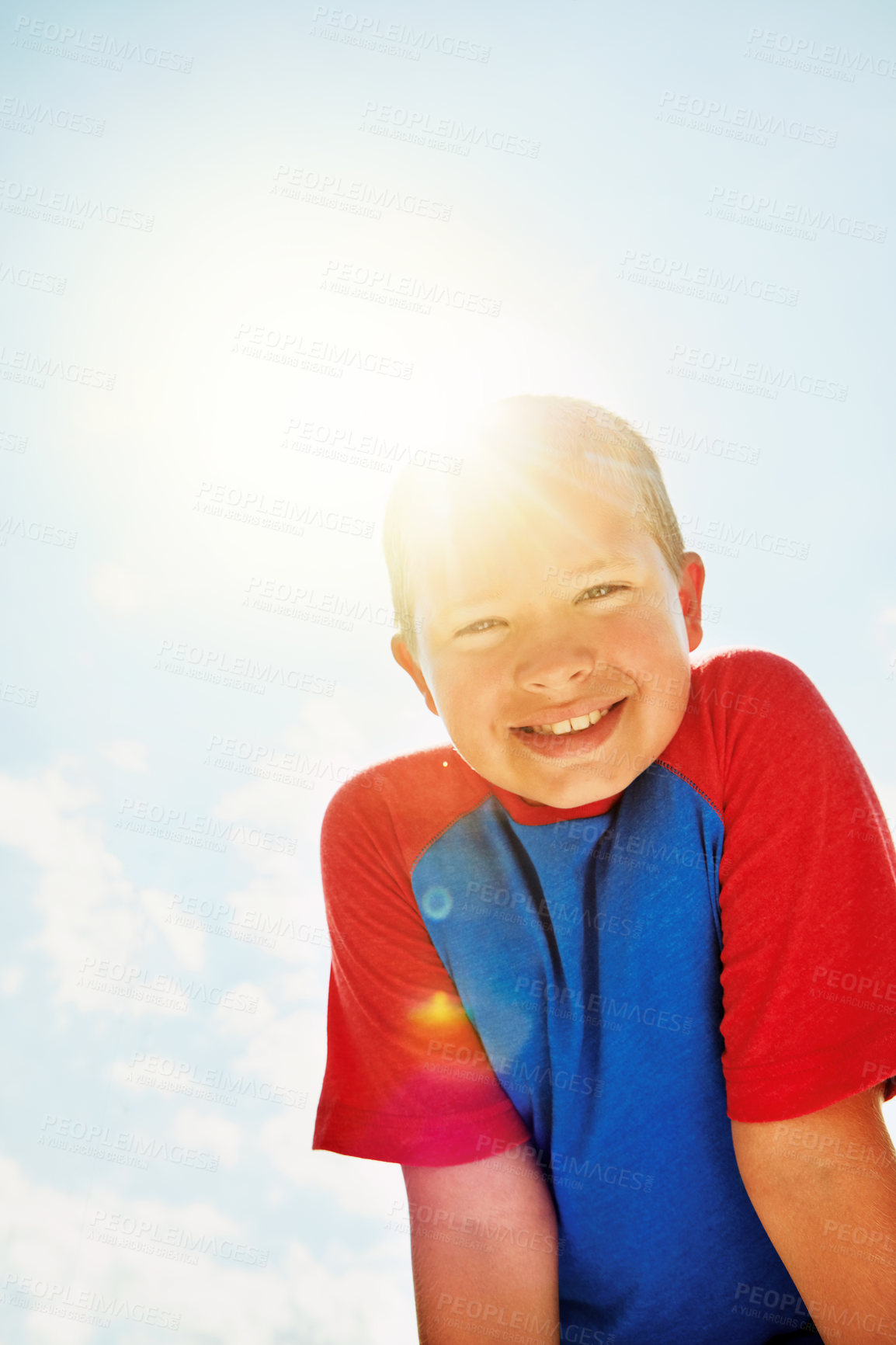 Buy stock photo Portrait of a happy boy standing outside on a bright summer’s day