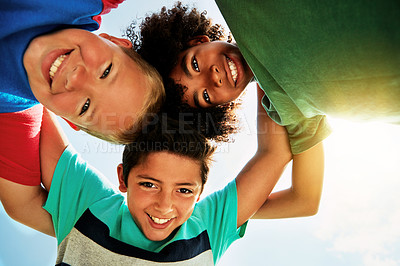 Buy stock photo Happy, blue sky and low angle portrait of children for friendship, playing and fun together. Diversity, youth and boys huddle in circle for childhood, game and hug for school, recess and playground