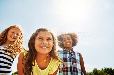 Buy stock photo Shot of a group of diverse and happy kids hanging out together on a bright day outside