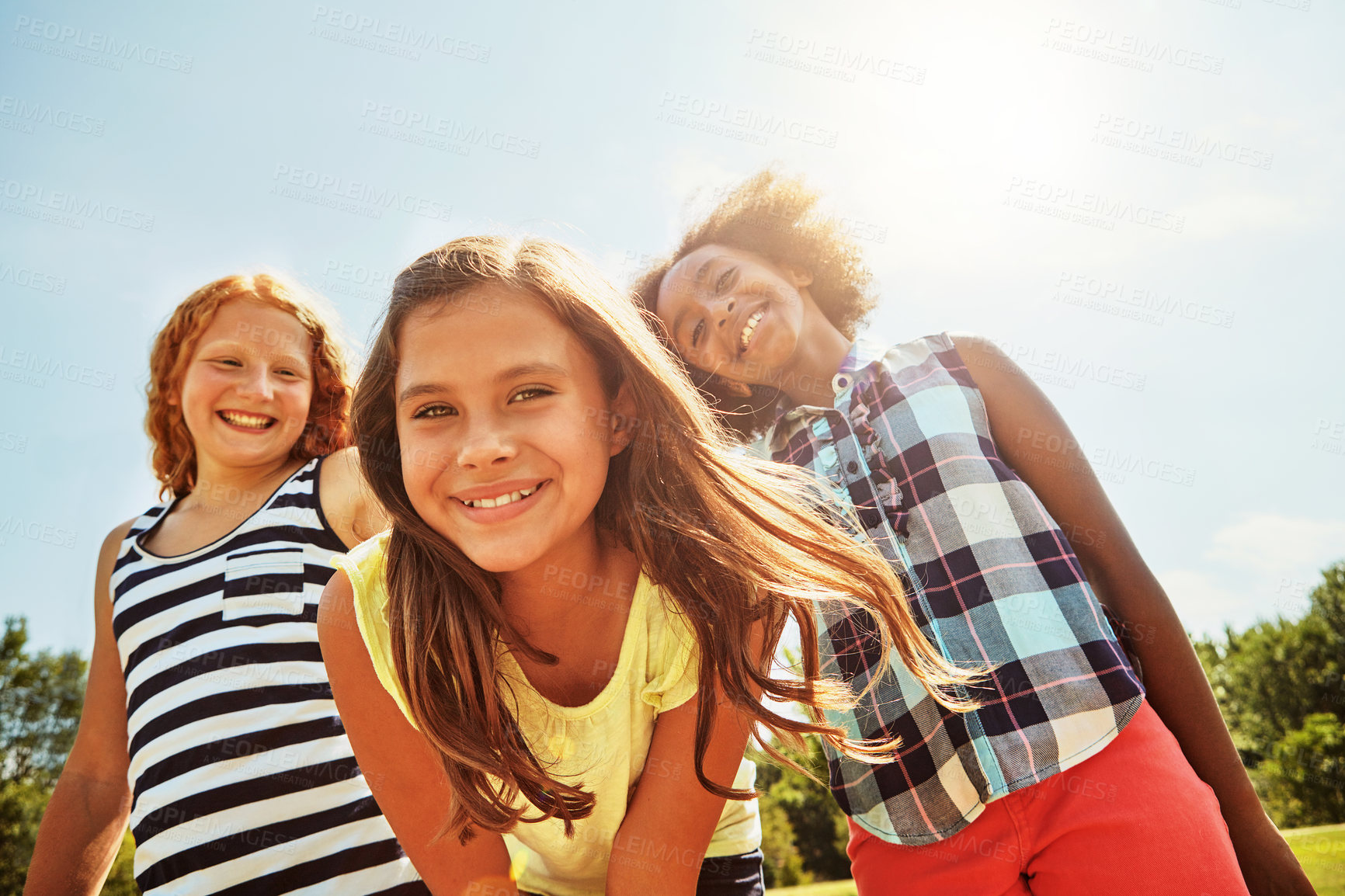 Buy stock photo Portrait of a group of diverse and happy kids hanging out together on a bright day outside