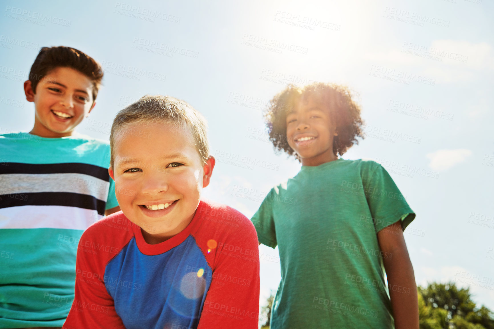 Buy stock photo Portrait of a group of diverse and happy kids hanging out together on a bright day outside