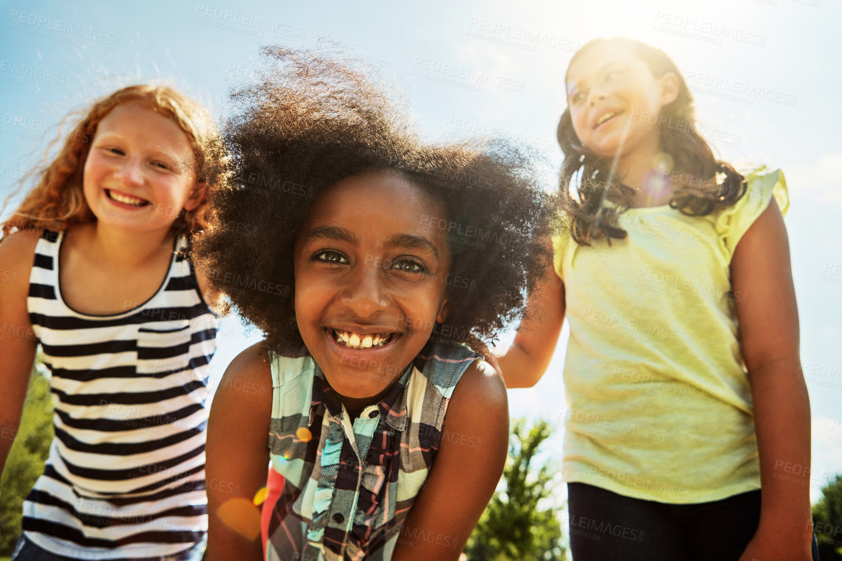 Buy stock photo Portrait of a group of diverse and happy kids hanging out together on a bright day outside