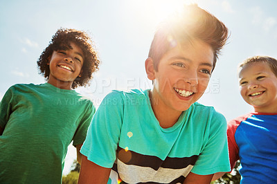 Buy stock photo Shot of a group of diverse and happy kids hanging out together on a bright day outside