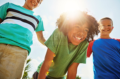 Buy stock photo Shot of a group of diverse and happy kids hanging out together on a bright day outside