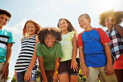 Buy stock photo Portrait of a group of diverse and happy kids hanging out together on a bright day outside