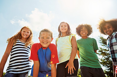 Buy stock photo Portrait of a group of diverse and happy kids hanging out together on a bright day outside