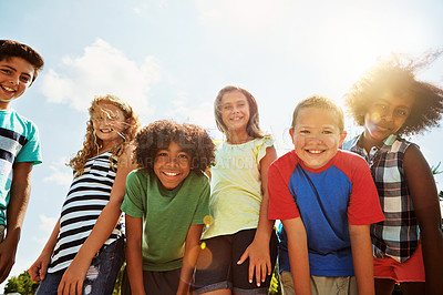 Buy stock photo Portrait of a group of diverse and happy kids hanging out together on a bright day outside