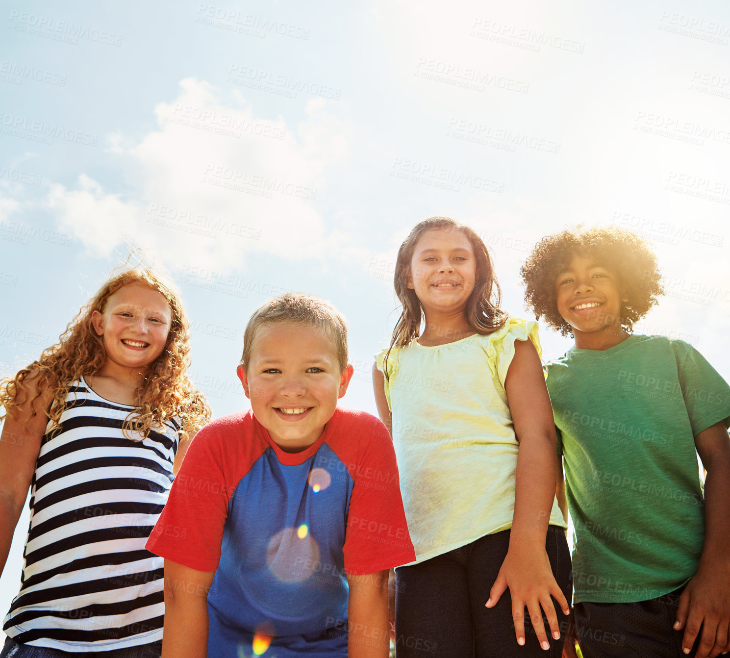 Buy stock photo Portrait of a group of diverse and happy kids hanging out together on a bright day outside