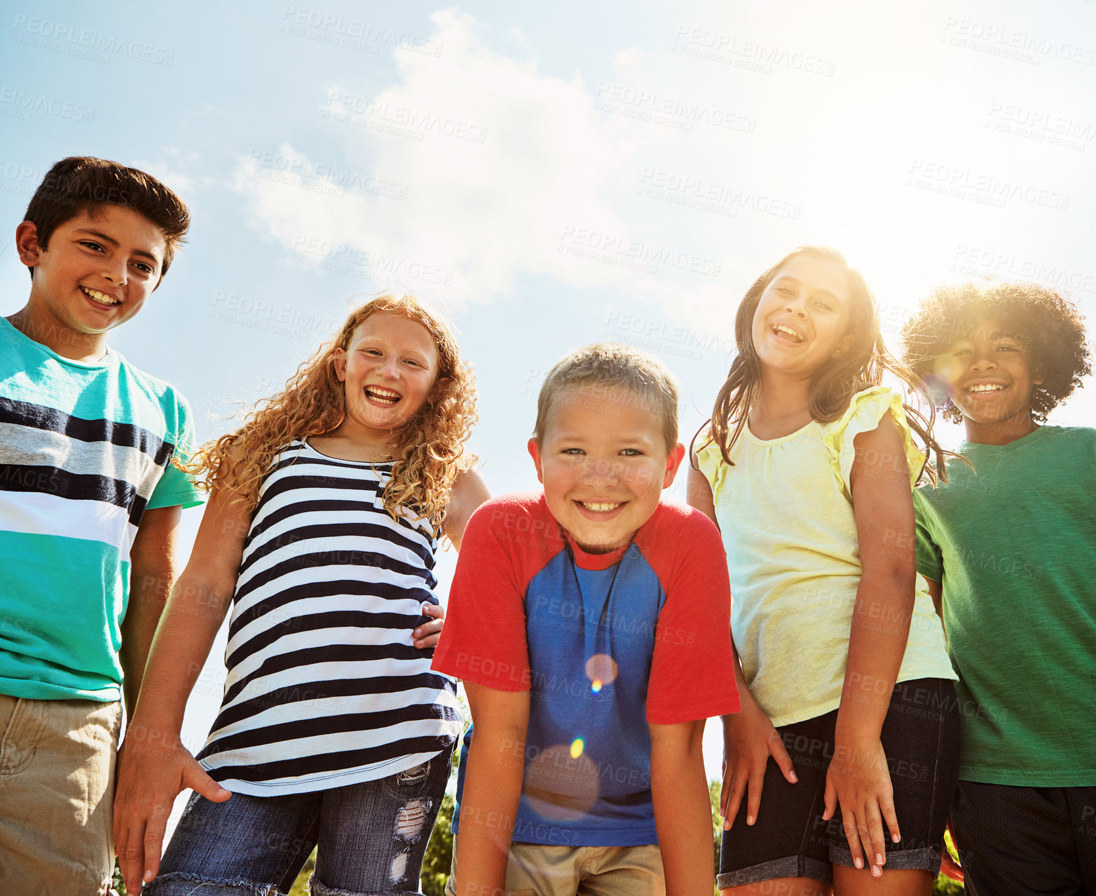 Buy stock photo Portrait of a group of diverse and happy kids hanging out together on a bright day outside