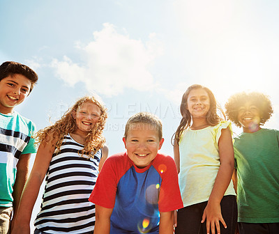 Buy stock photo Portrait of a group of diverse and happy kids hanging out together on a bright day outside